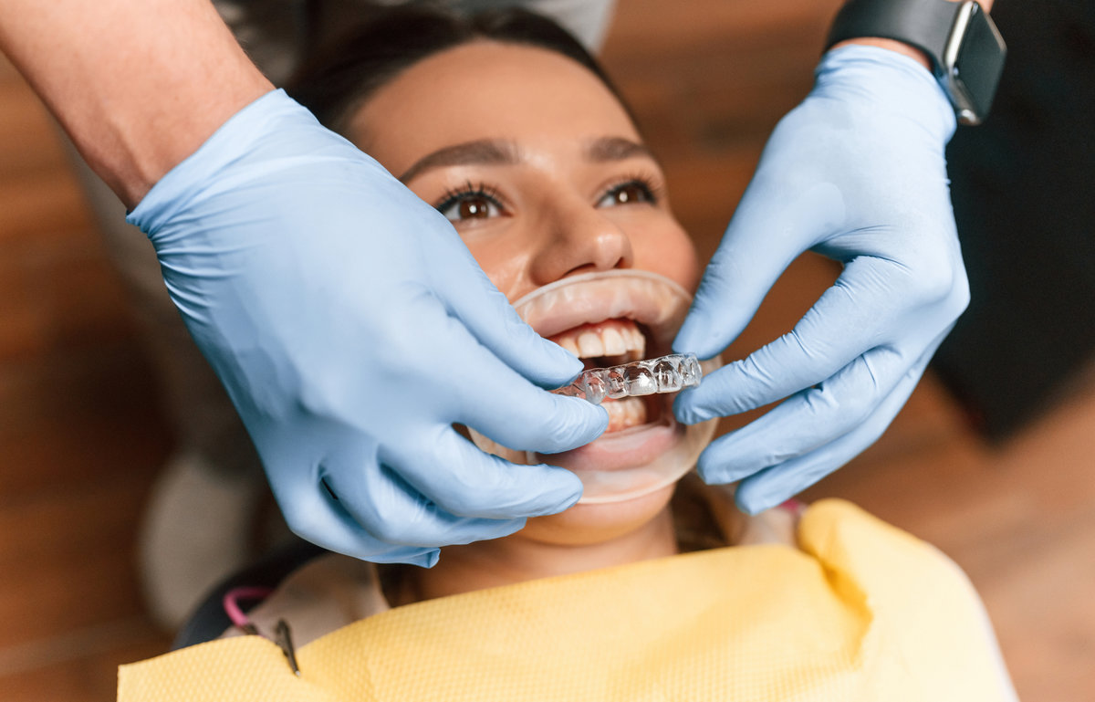 Lying on a chair. Installation of aligner. Woman in the stomatology clinic, visiting dentist.