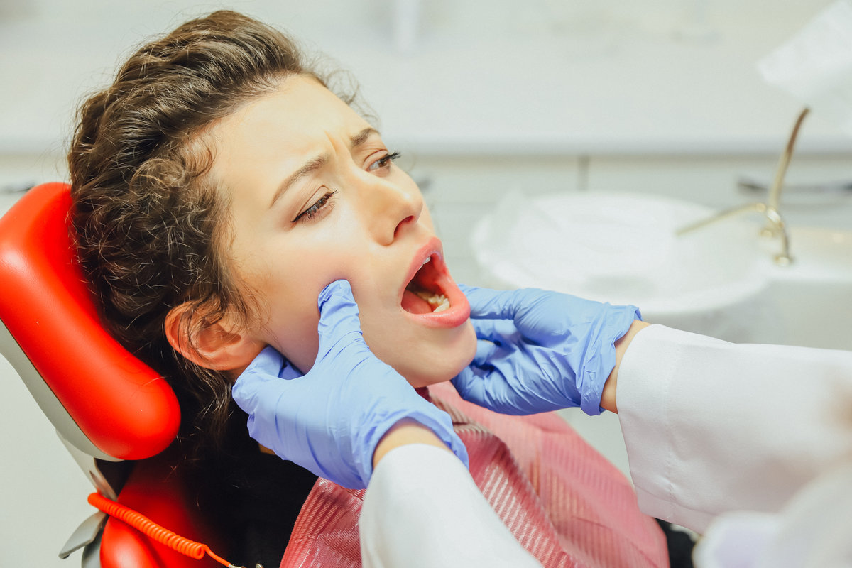The girl is at the reception of a dentist. Happy client at the dentist smiles. Tooth whitening. Dental clinic. Dental treatment in a modern clinic. Recovery of healing