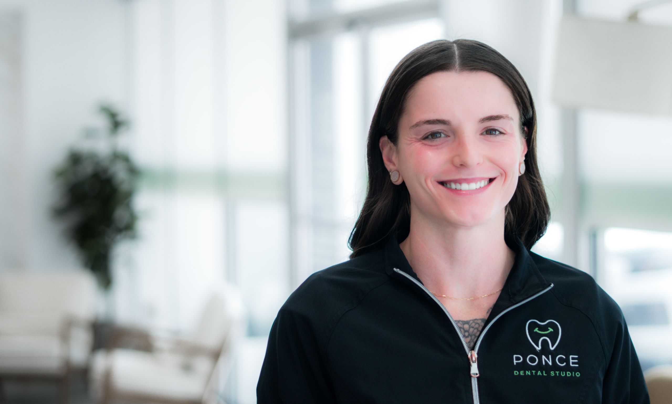 Jennie, Ponce Dental Studio team member, smiling in modern dental office